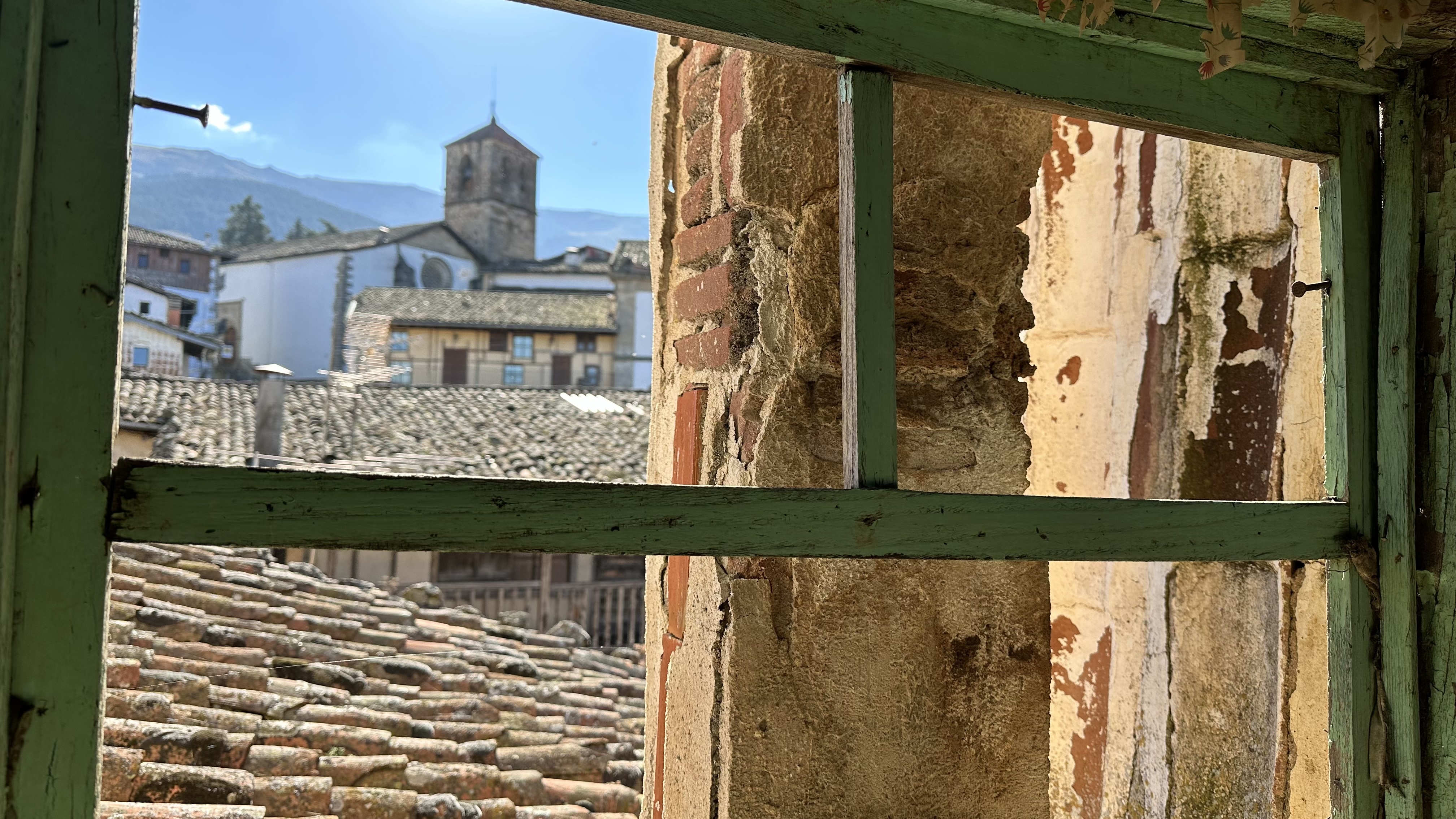 Current 2026 attic view toward the parish church of Nuestra Señora de la Asunción and the surrounding mountains from Casino Mayor